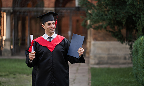 https://staging.pineoverseas.com/wp-content/uploads/2025/11/graduate-guy-graduation-gown-with-diploma-his-hands-campus.jpg